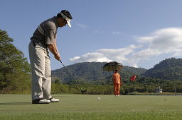 Man playing golf, Golf player and caddy, Kirimaya Golf Course, Khao Yai National Parc, Thailand