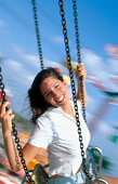 Woman on wave swinger carousel in amusement park. Florida. USA