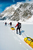 Pulling sledges under Broad Peak, Godwin-Austen glacier. Karakoram mountains, Pakistan