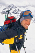 Young man carrrying climbing rope and ice axe on a ski tour, Ice climbing, Winter Sports, Sports, Stubai Alps, Tyrol, Austria