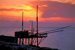 Fischernetz Gestänge im Sonnenaufgang in Trabucco, Punta Lunga bei Vieste, Gargano, Apulien, Italien
