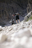 Mountain bikers carrying their bicyles, Tofane, Dolomites, Veneto, Italy