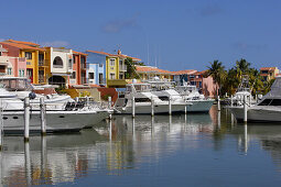 Boats are moored at Palmas del Mar harbour in front of colourful houses, Palmas del Mar, Puerto Rico, America