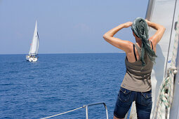 Segeltörn, Frau schaut auf ein Segelboot