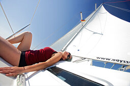 Sailing, woman sunbathing on a sailing boat
