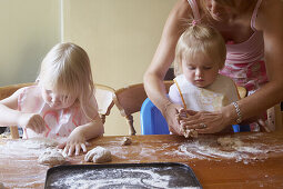 A mother baking with 2 young girls