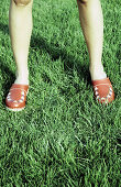  Adult, Adults, Anonymous, Clog, Clogs, Color, Colour, Contemporary, Country, Countryside, Daytime, Detail, Details, Exterior, Female, Footgear, Footwear, Grass, Human, Lawn, Leg, Legs, One, One person, Outdoor, Outdoors, Outside, People, Person, Persons,