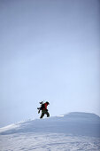 Snowboarder trägt Snowboard, Reutte, Tirol, Österreich