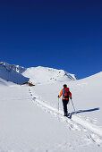 Skitourgeherin im Kleinwalsertal, Almhütte im Hintergrund, Allgäuer Alpen, Vorarlberg, Österreich