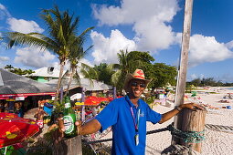Man smiling at camera, the Boatyard beach bar in background, Bridgetown, Barbados, Caribbean