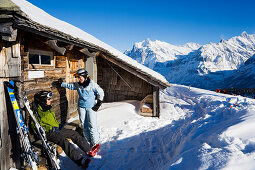 Skiläufer sitzen vor einer Almhütte, Männlichen, Grindelwald, Berner Oberland, Kanton Bern, Schweiz