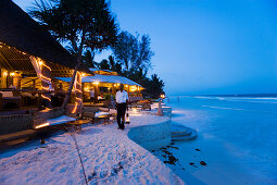 Waiter arranging lanterns, The Sands, at Nomad, Diani Beach, Kenya