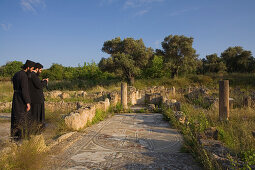 Two orthodox priests visiting Agia Trias, Mosaic Floor, Basilica ruins, Erenkoy, Gialousa, North Cyprus, Cyprus
