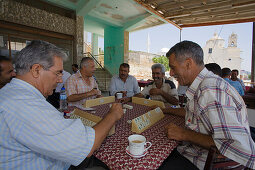 Local men sitting in a cafe playing a game, Kafenion, Dipkarpaz, Rizokarpaso, Karpasia, Karpass Peninsula, Cyprus