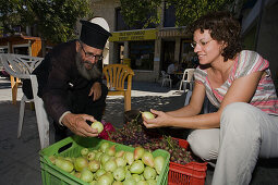 Monk, Priest selling fruit, Woman buying fruit at the market stall, Geroskipou, near Pafos, South Cyprus, Cyprus