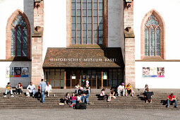 A group of young people sitting on steps in front of a church, Barfuesser Church, Historical Museum, Barfuesserplatz, Basel, Switzerland