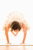 Frau mittleren Alters macht Yoga (Kranich), Yogastudio in Linz, Österreich