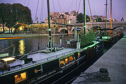 Houseboats on the banks of the Seine river in the evening, Paris, France, Europe