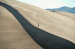 Woman running, Great Sand Dunes National Park near Alamosa. Colorado, USA