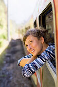 Young woman looking out of a window of a speeding train