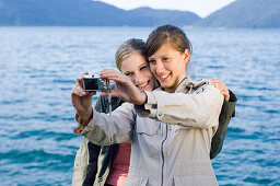 Two young women, girls, taking a photograph of themselves, Lake Walchensee, Upper Bavaria, Bavaria, Germany