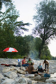 Group of young people grilling at river Isar, Munich, Bavaria, Germany