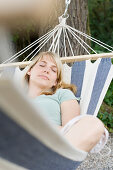 Middle aged woman lying in a hammock, relaxation, Bavaria, Germany