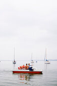 Family in a pedal boat on lake Ammersee, Bavaria, Germany