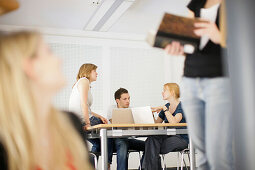 Students with laptops holding a conversation, discussion, University, Education