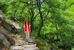 Mid adult woman walking over cobbled path, Ticino, Switzerland