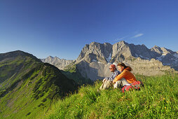 Couple resting on meadow, Karwendel range, Tyrol, Austria