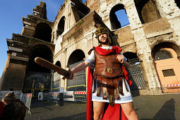 Man wearing uniform of Roman legionarie standing near Colosseum, Rome, Italy