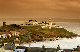 Houses and lighthouse on shore in the evening, Roche's Point, County Cork, Ireland, Europe