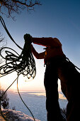 A man throwing a climbing rope at sunset, Hokkaido, Japan, Asia