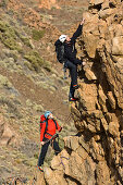 A couple climbing on a ridge, Teide National Park, Tenerife, Canary Islands