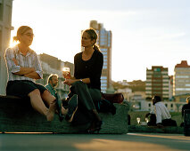 People sitting at the promenade in the light of the evening sun, City-to-Sea-Bridge, Wellington, North Island, New Zealand
