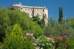 Das Schloss Château Suze-la-Rousse hinter blühenden Büschen und Bäumen, Drome, Provence, Frankreich