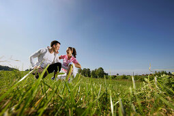 Couple crouching on grass