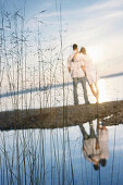 Couple standing at lakeshore, Ambach, Lake Starnberg, Bavaria, Germany
