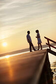 Couple standing on a jetty a Lake Starnberg, Ambach, Bavaria, Germany