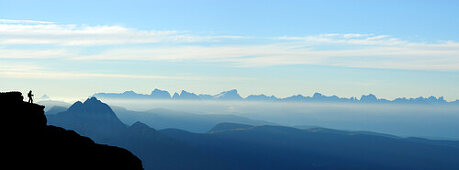 silhouette of hiker in front of panorama Dolomites with Iffinger Spitze, Piz Boe, Langkofel, Plattkofel, Marmolada, Kesselkogel, Rosengartenspitze and Palagruppe, Spronser Joch, Texelgruppe range, South Tyrol, Italy