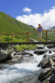 Frau auf einer Brücke über einen Bach, Lazinstal, Texelgruppe, Ötztaler Alpen, Südtirol, Italien