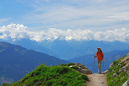 young woman on trail above valley of Maria Alm with view to Hohe Tauern range, Steinernes Meer range, Berchtesgaden range, Salzburg, Austria