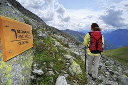 Female hiker passing sign National Park Hohe Tauern, Tyrol, Austria