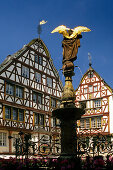 Sculpture on a fountain and half-timbered houses under blue sky, Bernkastel-Kues, Rhineland-Palatinate, Germany