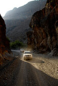 Zwei Geländewagen auf einer Strasse in den Bergen, Al Hajar Berge, Wadi Bani Auf, Oman, Asien