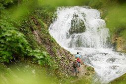 Hikers near waterfall, Werdenfelser Land, Bavaria, Germany