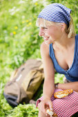 Junge Frau isst eine Brezel, Werdenfelser Land, Bayern, Deutschland