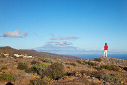 Hiker looking at view at Teide volcano and at the sea, La Gomera, Canary Islands, Spain, Europe