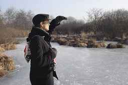 Senior man with ice skates at lake Ammersee, Upper Bavaria, Germany